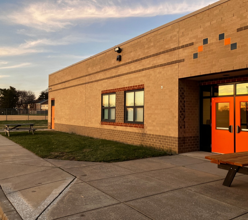 Exterior of the back of Oakland Mills High School at dusk.